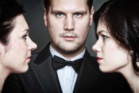 Relations between men and women - triangle. Passion of love hate. Infatuation love. Mistress betrayal within the family. Choice before wedding. Black backgroundの写真素材