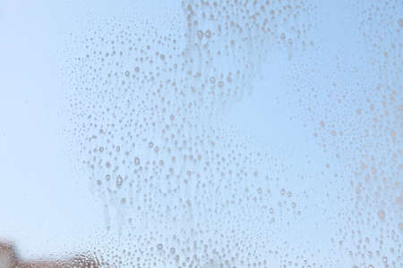 Drops on the windowpane, cleaning window with spray detergent. Glass cleaner on pane.