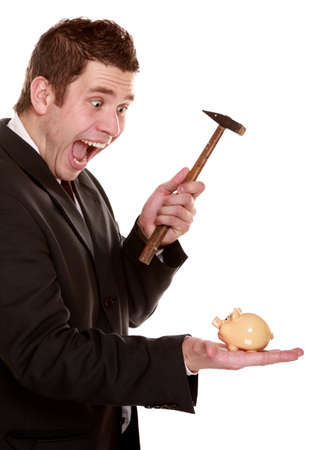 shouting funny business man breaking piggy bank with hammer, shocked apprehensive facial expression, isolated on whiteの写真素材