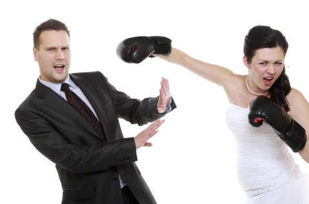 Bad relationship. Funny wedding couple expressive fighting. Woman showing her husband who's boss. Angry wife boxing husband. Isolated on whiteの写真素材