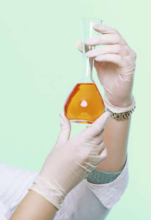 female hand chemist laboratory assistant or scientific researcher with chemical glassware test...
