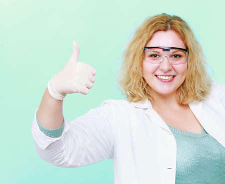 Happy chemist woman or girl student or female laboratory assistant or scientific researcher showing  thumb ub gesture. Isolated on white backgroundの写真素材