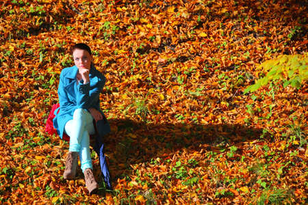 Young  thoughtful pensive woman outdoor, sad unhappy girl thinking in the autumn park. Loneliness stress depression.の写真素材