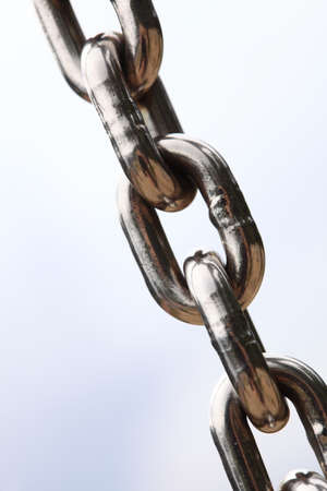 Chain Links closeup of a metal steel chain link segment from a children's swing set. Sky background.の写真素材