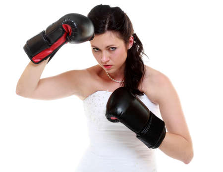 Emancipation idea concept. Bride in wedding dress wearing boxing gloves. Woman showing her power dominationの写真素材