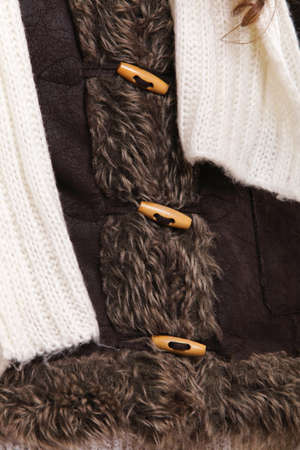 winter fashion warm clothing part of fur jacket with wooden button as wear backgroundの写真素材