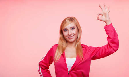 young sporty fitness woman happy smiling girl showing OK sign hand gesture.