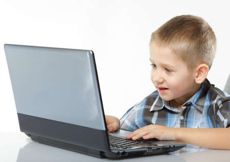 Computer addiction child boy with laptop notebook white backgroundの写真素材
