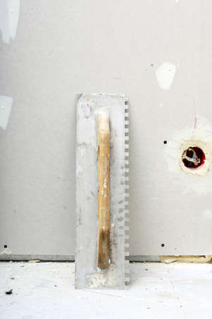 construction equipment dirty old trowel used for masonry on rough unfinished concrete surface