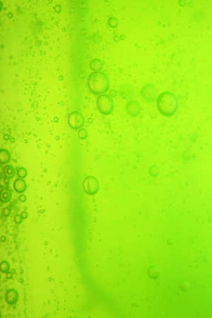 Green abstract blurred liquid background with soap bubblesの写真素材