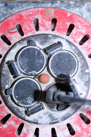 Close up old dirty extension electric cable cord reel on construction site