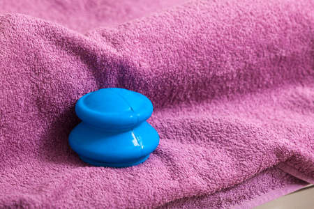 Blue rubber cupping glass on pink towel for vacuum massage therapy, traditional chinese medicine. Alternative madical procedure,の写真素材