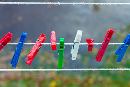 Colorful clips for washing laundry on strip rope outdoor. Background. Housework concept.