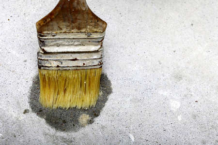 Improvement renovation at home. Construction site tile adhesive brush on floorの写真素材