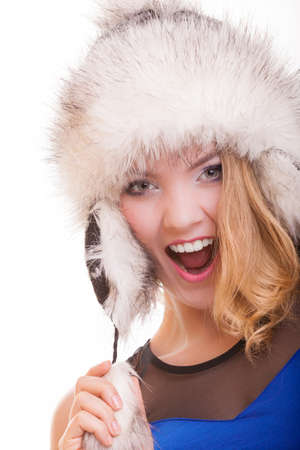 Happy blond girl young woman in warm fur hat. Winter clothes. Fashion and beauty. Studio shot. Isolated on white background.の写真素材
