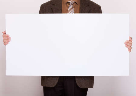 Advertising concept. Businessman holding blank sign empty billboard pointing space for text. Male hands with white banner.の写真素材