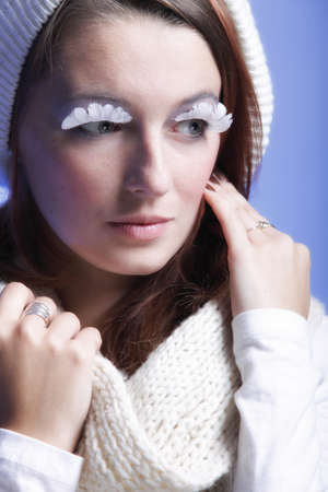 winter fashion beautiful woman in warm clothing stylish creative make up false long white eye lashes...
