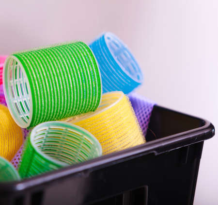 Colorful hair rollers curlers in black basket in hairdressing beauty salon. By hairdresser hairstylist. Hairstyle.の写真素材