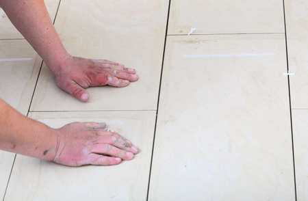 Home improvement, renovation - construction worker tiler is tiling, ceramic tile floor adhesive