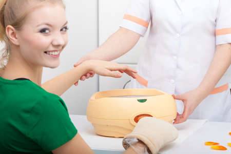 Happy woman in beauty spa salon with paraffin wax bowl  Skin body care の写真素材