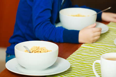 Two white bowls with corn flakes breakfast morning meal at the table. Home.の写真素材