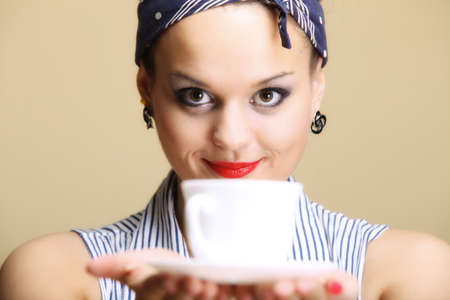Hot beverage. Woman funny girl holding a cup of tea or coffee copyspace brown backgroundの写真素材