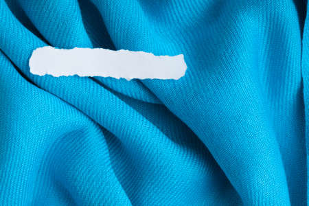 Blank copy space scrap of paper on blue background cloth wavy folds of textile texture design of elegant materialの写真素材