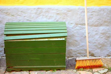 Outdoor big green wooden box and red broom for house work on concrete wallの写真素材
