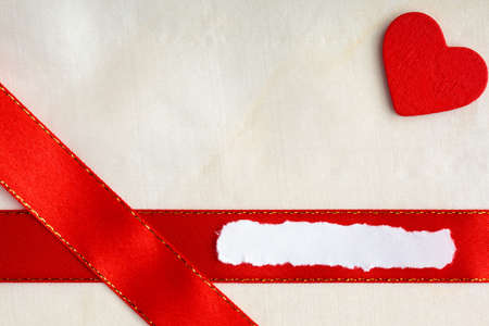Red satin ribbon with wooden heart on clothの写真素材