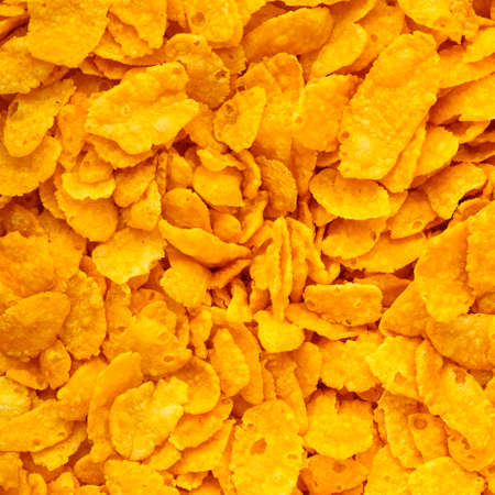 Closeup of many corn flakes breakfast morning meal as food background. Diet and healthy nutrition. Square format.の写真素材