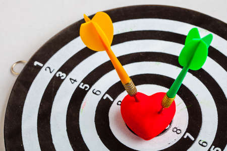 Closeup of black and white target with two dart in red valentine heart love symbol as bullseye. Skeet trap shooting sport in valentines day.の写真素材