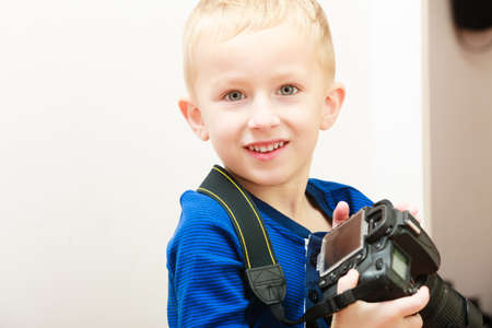 Happy childhood. Portrait of smiling boy child kid preschooler playing with camera. At home. Real.