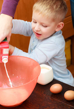 Happy childhood  Boy kid baking cake  Child preschooler pouring mik into a bowl  Kitchen  Real の写真素材