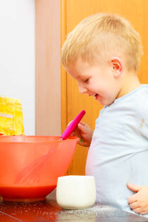 Happy childhood  Boy kid baking cake  Child preschooler beating with wire whisk in bowl  Kitchen  Real の写真素材