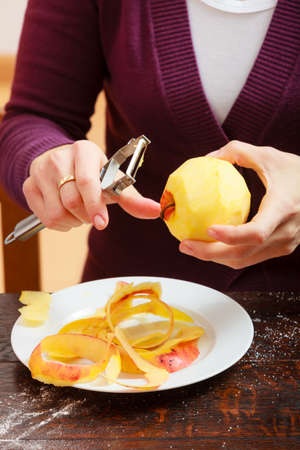 Female hands peeling apple healthy fruit  Woman housewife making drop scones  Diet and nutrition  At home の写真素材