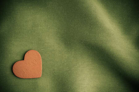 Valentine s day background  Red decorative heart on abstract green wavy folds cloth or textile...