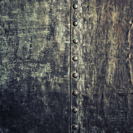 Closeup of grunge black metal plate with rivets and screws as texture. Square format.の写真素材