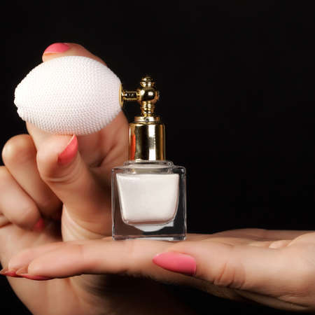 Sensuality concept  Female hand with perfume bottle on black のeditorial素材