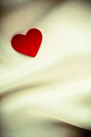 Valentine s day or wedding  Red decorative heart on abstract white luxury cloth silk or satin textile with copy space の写真素材