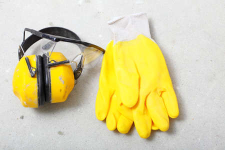 Renovation at home. Construction equipment tools work gloves yellow protective noise muffs in building site.の写真素材