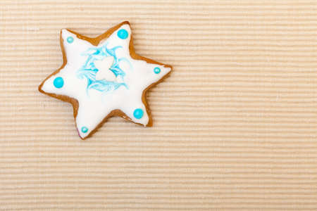 homemade gingerbread cake star with icing and blue decoration on brown as christmas background  holiday handmade conceptの写真素材