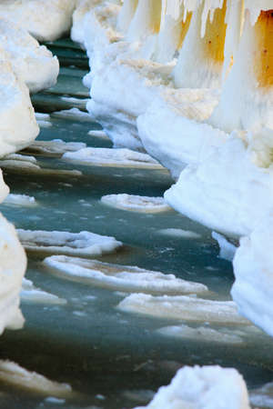 Winter scenery. Close up detail of old pier in Gdynia Orlowo Poland with ice formations icicles....