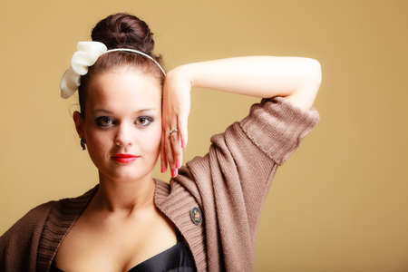 Portrait of young beautiful woman sexy girl retro style make-up and hair bun on brown backgroundの写真素材