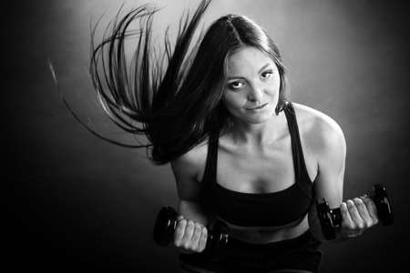 Fitness girl fit woman lifting dumbbells weights doing exercise with dumb bells training shoulder...
