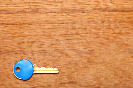 House key with blue plastic coats caps on wooden table background. Copy space for textの写真素材