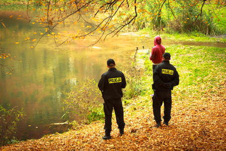 Polish police officers    checking fisherman in autumnal park  Fishing inspection  Law 