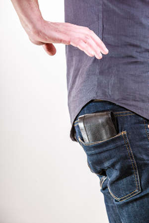 Closeup  Thief stealing wallet from back pocket of careless man  Risk of theft  Isolated on white ...