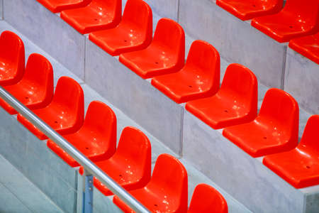 Closeup of red sport stadium seats. Empty stand. Team sport and football supporters fans.の写真素材