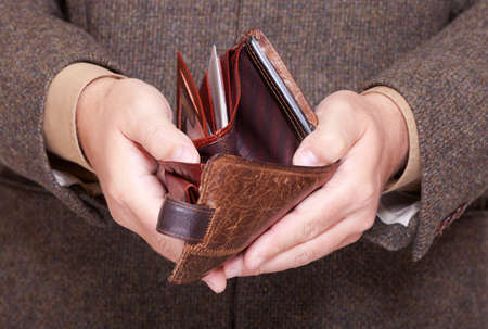 Broke businessman showing brown leather empty wallet  Business concept- finance and poor economy 