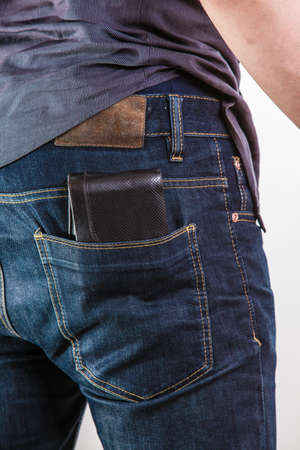 Closeup. Careless man with wallet on his back pocket. Risk of theft. Isolated on white. Studio shot.の写真素材